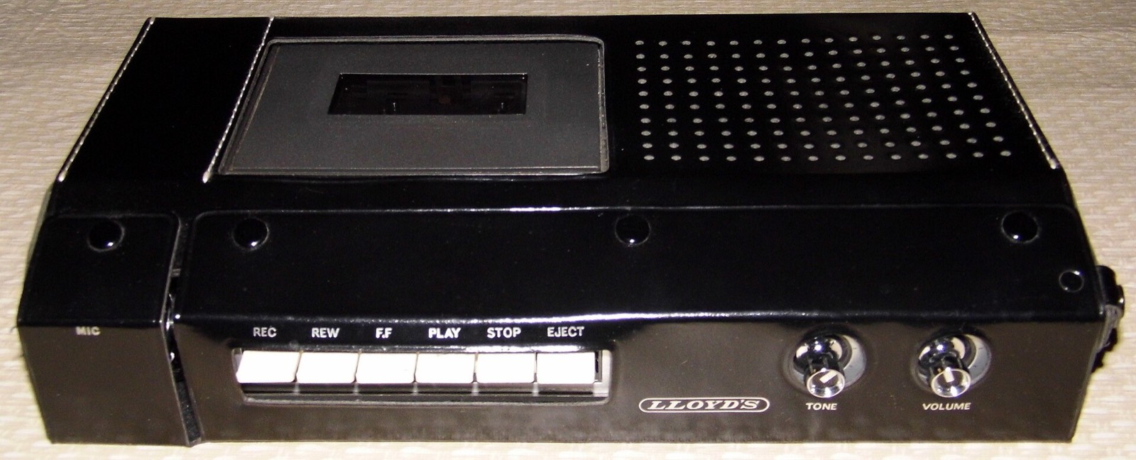 A portable cassette recorder from the 1970s with its transport buttons and speaker grille
